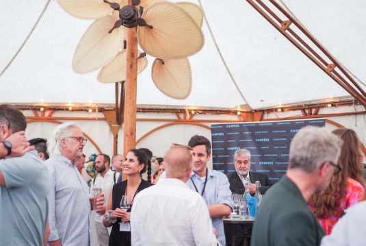 People in a tent having a drink together talking and laughing