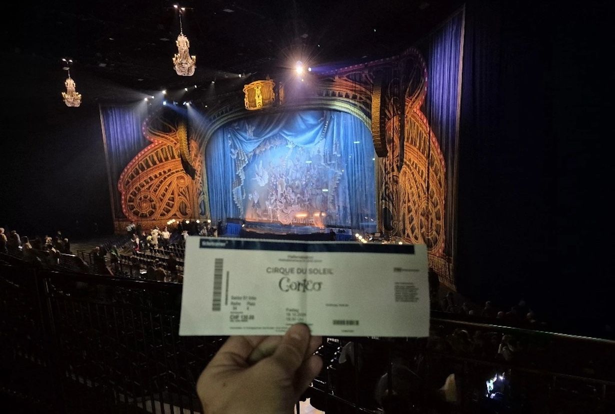 man holding entrance ticket in front of the Cirque du Soleil stage